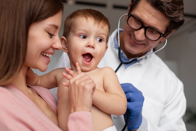 Photo jeune maman au cabinet du pédiatre pour l'examen de son bambin