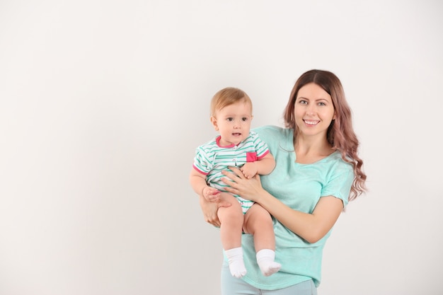 Jeune maman avec bébé sur une surface blanche