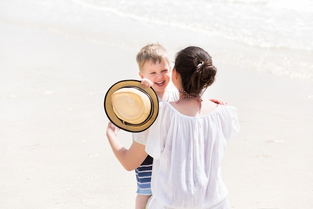 Jeune maman embrasse son enfant garçon aux vacances d'été