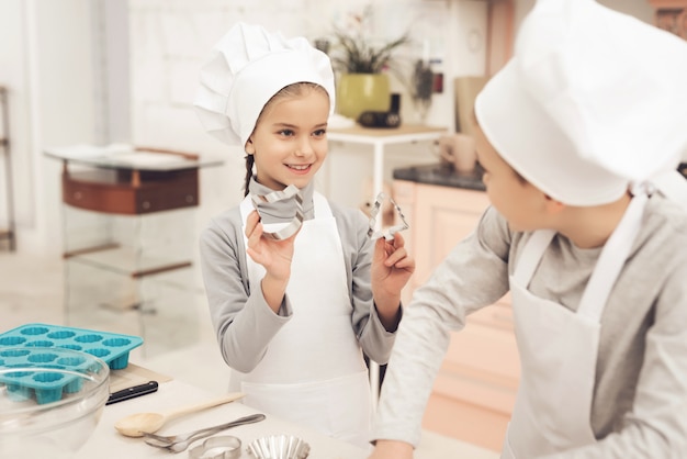 Jeune maman et enfants heureux ensemble à la cuisine.