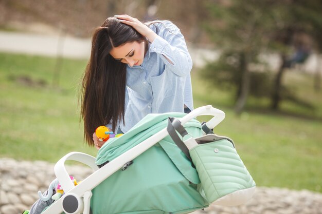 Jeune maman essayant de calmer son petit bébé à l'extérieur