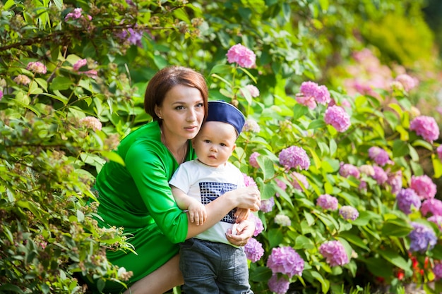 Jeune maman heureuse avec bébé pour une promenade dans le parc