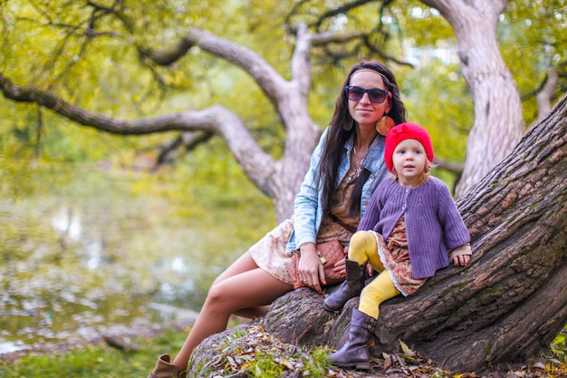 Jeune maman marchant avec sa petite fille en automne parc