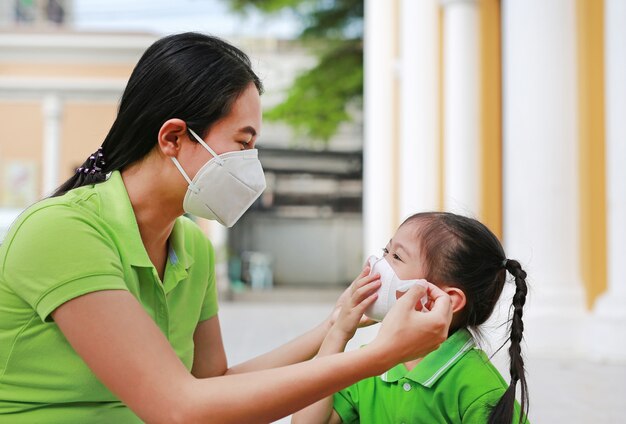 Jeune maman portant un masque de protection pour sa fille