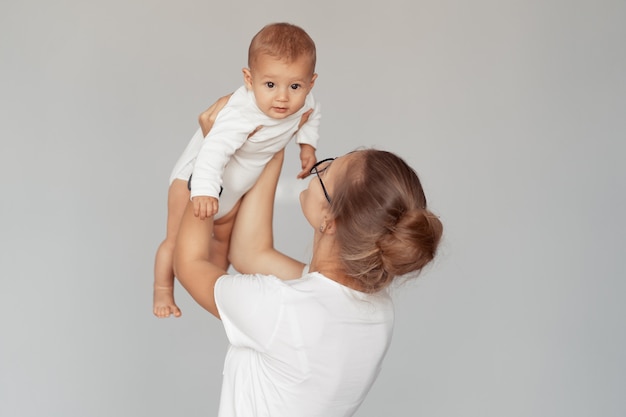 Jeune maman s'amuse avec son bébé à la maison