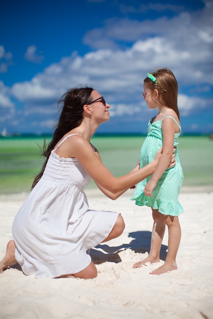 Jeune maman et sa fille mignonne s'amusent sur la plage exotique