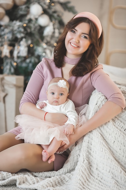 Jeune maman avec sa petite babygirl avec décoration de Noël