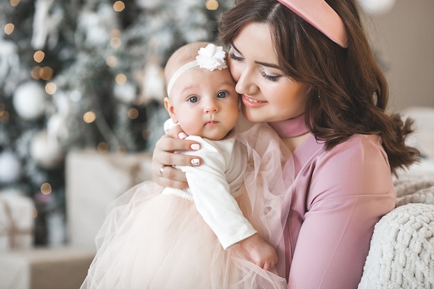 Jeune maman avec sa petite babygirl avec décoration de Noël