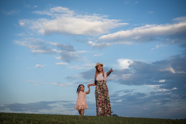 Jeune maman et sa petite fille marchant dans le parc