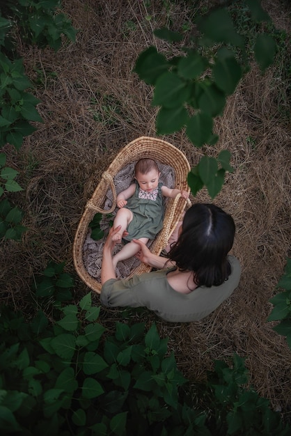 Photo jeune maman se promène avec sa petite fille dans le parc verdoyant.