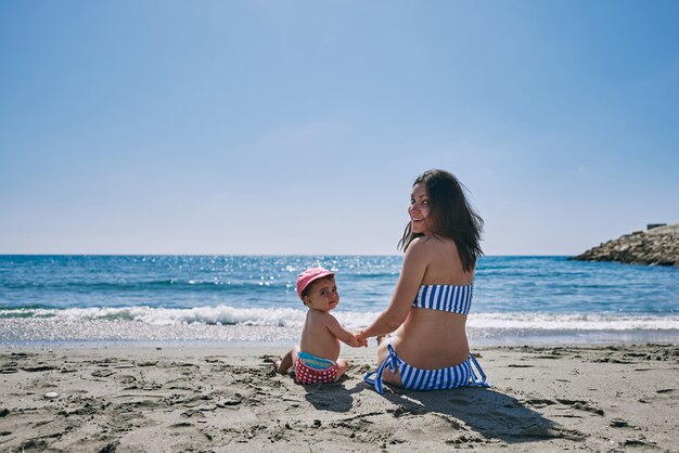 Une jeune maman avec son bébé au bord de la mer