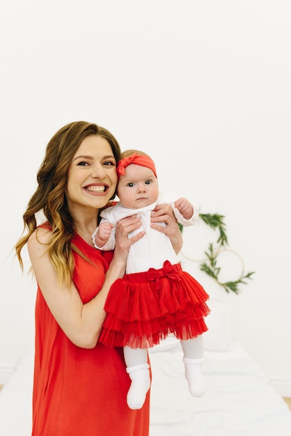 Jeune maman tenant sa petite fille en souriant. Fille et maman caucasienne.