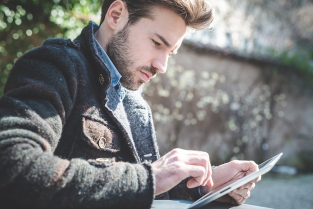 jeune mannequin beau à l&#39;aide de tablette homme