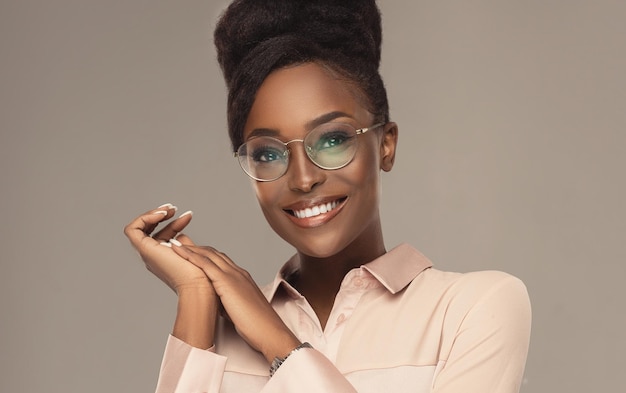 Jeune mannequin à la peau riche en mélanine dans les lunettes Cheveux afro denses naturels réunis en un gros chignon