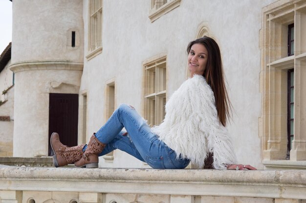 Jeune mannequin posant à l'extérieur près d'un vieux château historique