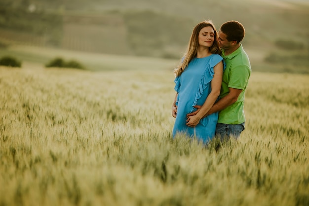 Jeune mari et sa femme enceinte dans le champ d'été