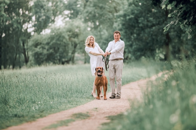 Le jeune mari et sa femme s'amusent avec leur chien de compagnie. le concept d'un mode de vie sain