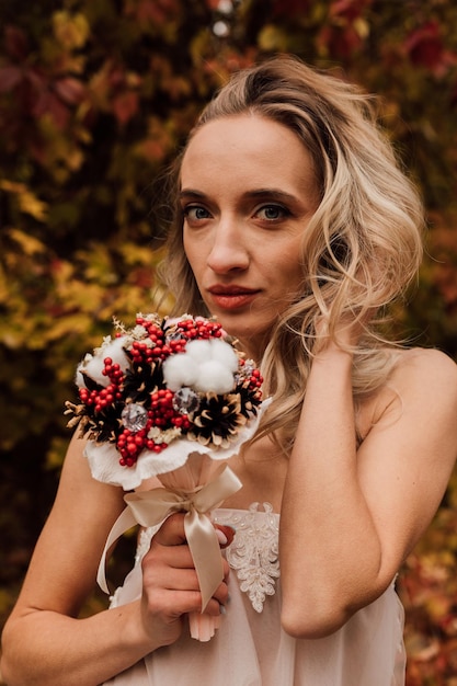 Jeune mariée blonde belle fille sexy posant avec un bouquet