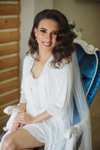 Jeune mariée gourmande classique. Photo de mode intérieure en studio d'un mannequin en robe de mariée