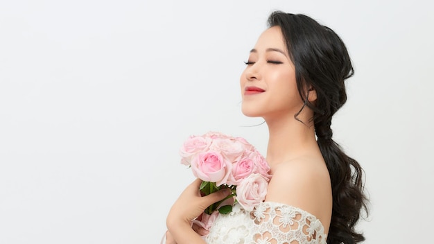 Jeune mariée heureuse avec bouquet de fleurs