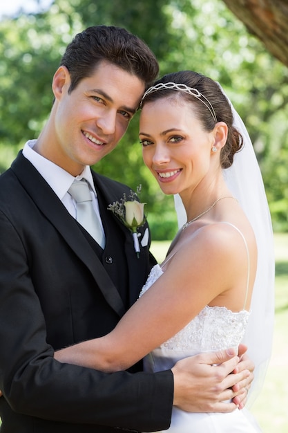 Jeune mariée et le marié étreindre dans le jardin