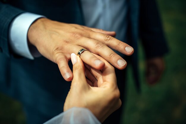 Jeune mariée a mis une bague de mariage en or sur le doigt du marié