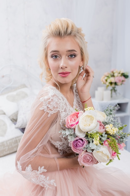 Jeune mariée mode beauté dans un décor d'hiver avec bouquet de fleurs dans ses mains. Maquillage et coiffure de mariage belle mariée portrait.