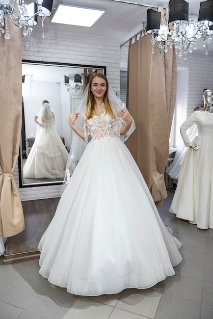 Jeune mariée souriante posant en robe de mariée