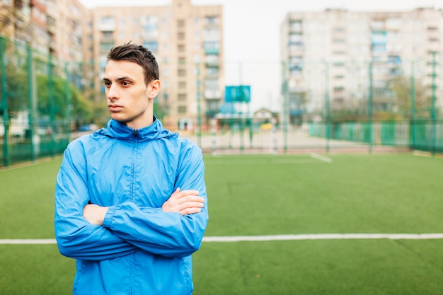 Un jeune mec fait du sport, portrait, beau mec en tenue de sport. Le gars travaille en plein air et frais.