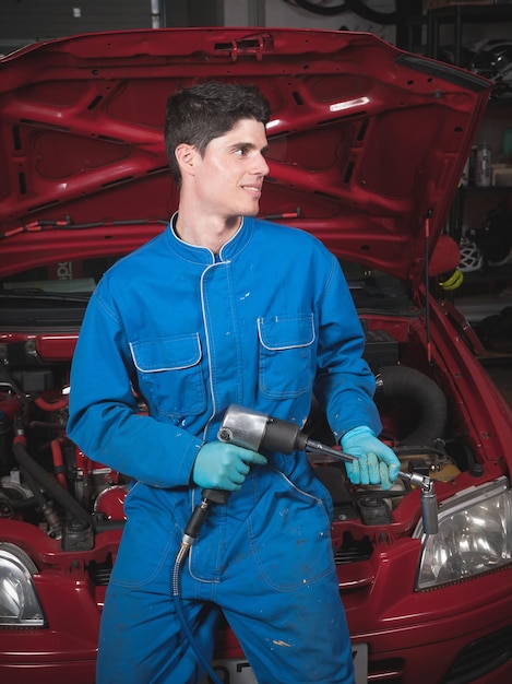 Jeune mécanicien travaillant sur une voiture.
