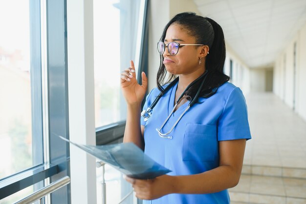 Jeune médecin afro-américain professionnel examinant la radiographie de la poitrine du patient