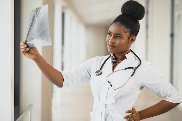 Jeune médecin afro-américain professionnel examinant la radiographie de la poitrine des patients