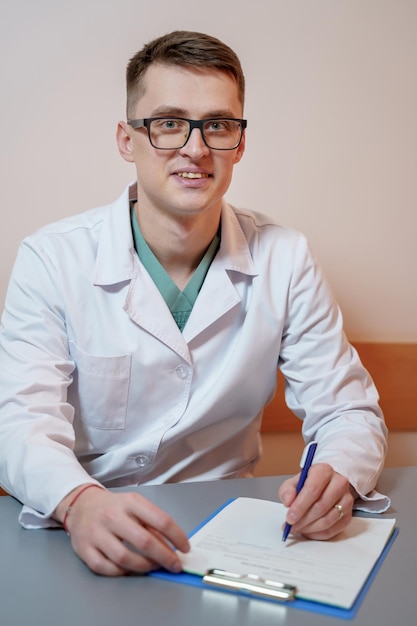 Jeune médecin assis dans son bureau derrière un bureau