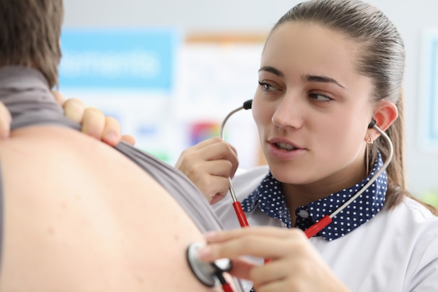 Jeune médecin ausculter le dos