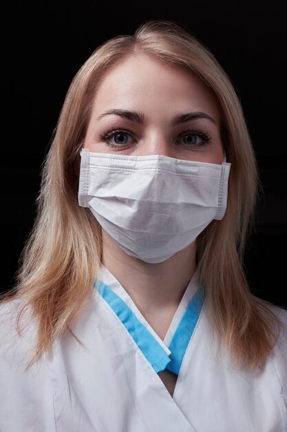 Jeune médecin blonde avec un masque protecteur