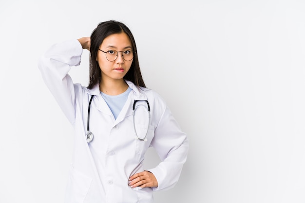 Jeune médecin chinois femme isolée toucher l'arrière de la tête, penser et faire un choix.