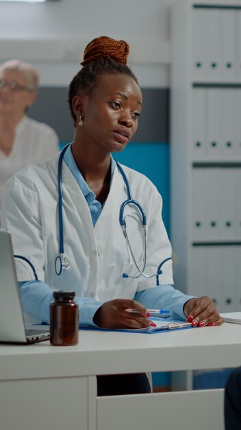 Jeune médecin consultant un patient âgé invalide pour un contrôle