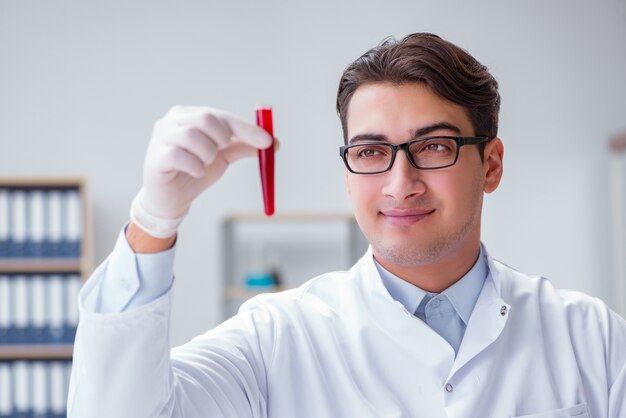 Jeune médecin dans le laboratoire avec tube rouge