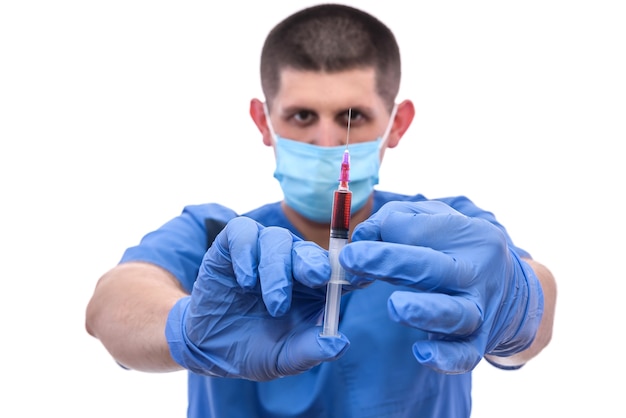 Jeune médecin avec du sang en seringue isolé sur blanc.