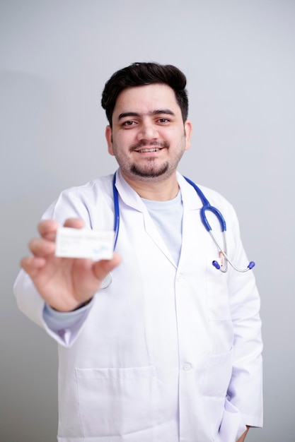 Photo un jeune médecin est debout et tient un médicament à la main