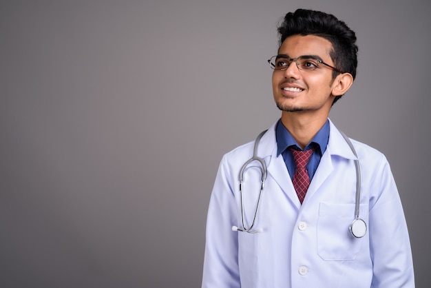 Jeune médecin indien contre mur gris