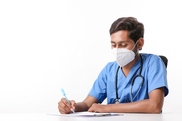 Jeune médecin indien écrit sur le bloc-notes à la clinique.