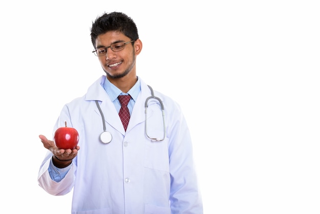 Jeune médecin indien heureux souriant tout en tenant la pomme rouge