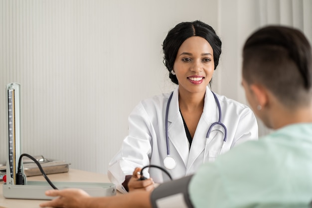 Un jeune médecin mesure la pression artérielle du patient.