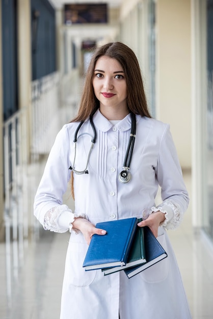 Jeune médecin pédiatre expérimenté avec journal patient debout à l'hôpital