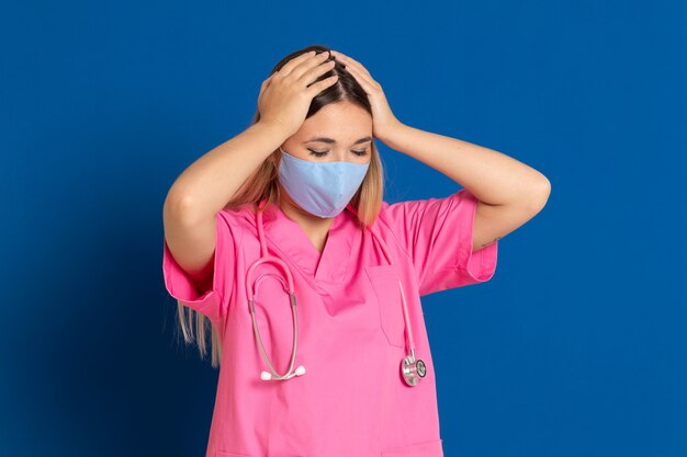 Jeune médecin portant un masque et un uniforme rose