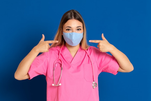 Jeune médecin portant un masque et un uniforme rose