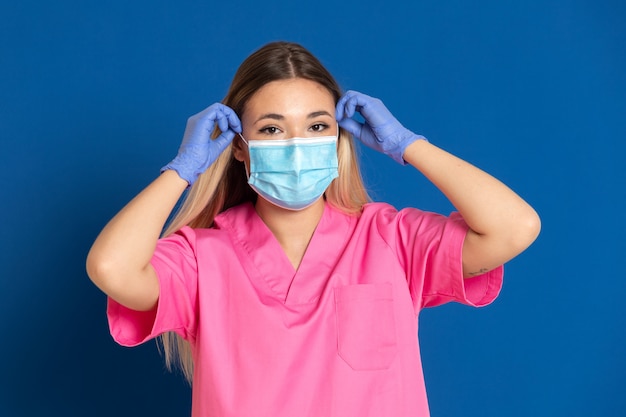 Jeune médecin portant un masque et un uniforme rose