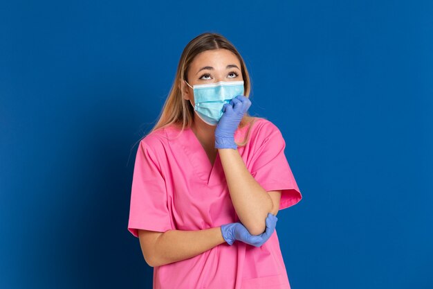 Jeune médecin portant un masque et un uniforme rose