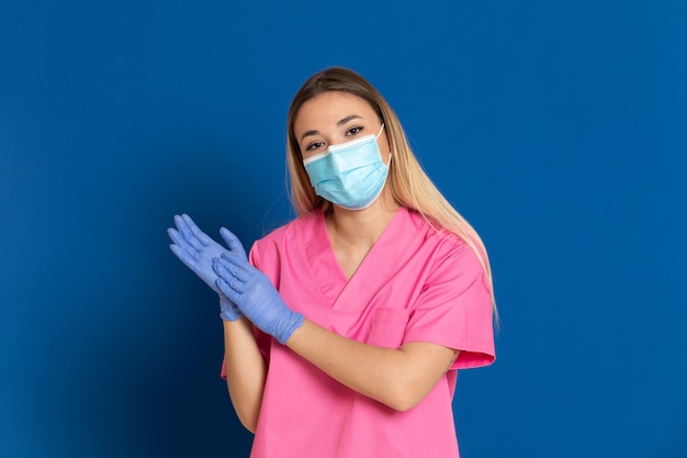 Jeune médecin portant un masque et un uniforme rose